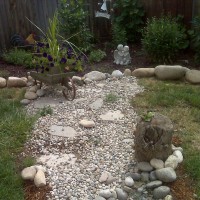 Photo Thumbnail #1: old wheelbarrow and tree stump with frog...