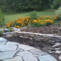 Photo Thumbnail #22: Building a stone retaining wall in our back yard.