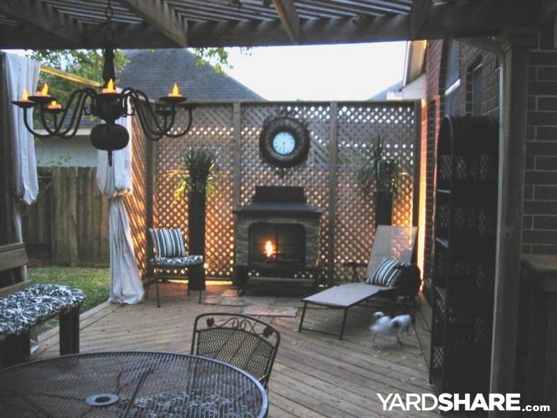 Outdoor patio fireplace with curtains and cozy seating